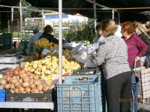 野外の市場で野菜を買うセニョーラたち。ふくよかな体型の女性が目立つ